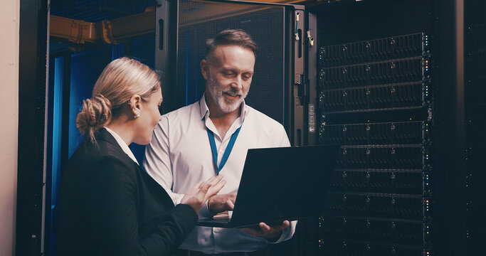 Laptop, collaboration and people with in server room for technical support, database or cybersecurity. Computer, teamwork and technicians with system upgrade in data center for network programming.