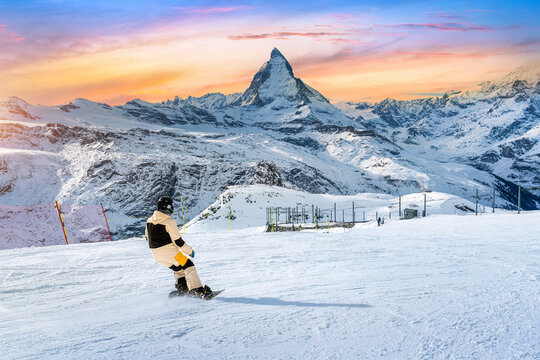 Skier skiing on the ski slope towards Matterhorn mountain in ski resort. Zermatt, Switzerland.