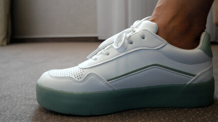 Women's hands tie shoelaces in sneakers. A woman tries to see if the shoes are comfortable. Women's...