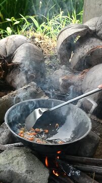 Cooking mie nyemek in a rice field with traditional outdoor style and rustic countryside atmosphere. Indonesian noodle dish prepared in a natural rural environment, showcasing local culinary culture, 