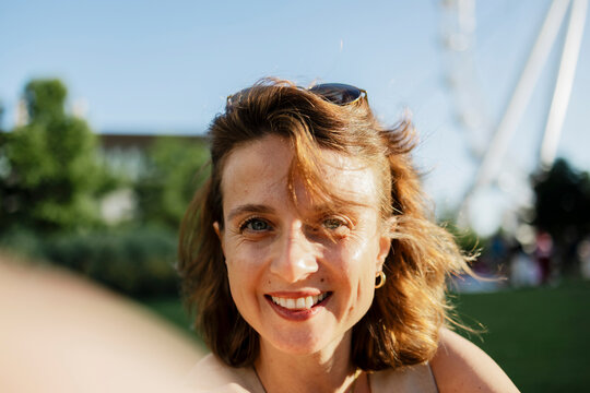 Smiling woman enjoying leisure time outdoors in sunny park