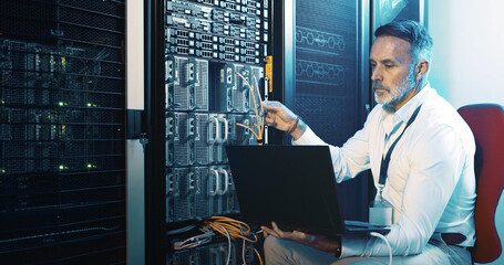 Server room, programmer and man with laptop, hardware problem solving and network inspection. IT specialist, mature person and employee with pc, cyber security and tech upgrade with maintenance