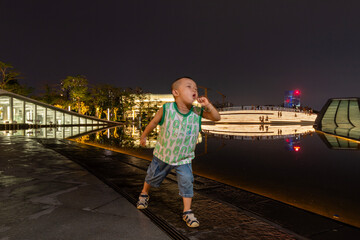 little boy playing in guangzhou at night