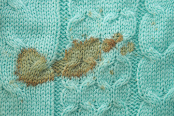 Green sweater with visible stains and damage