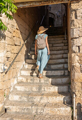 A stunning young woman with amazing looks walks along a beautiful street in the old city of Jaffa. Israel.