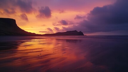 Vibrant sunset over a tranquil beach with dramatic cliffs reflected in the water.