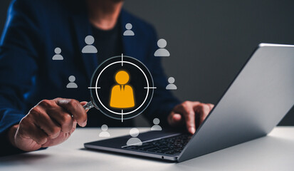 A person targets user profiles on a laptop, indicating a focus on digital engagement or analytics in a professional setting.