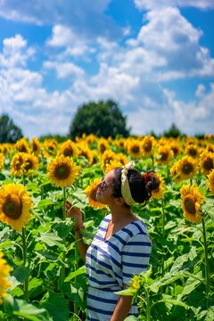 Woman enjoying freedom in beautiful sunflower field during summer