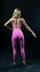 Obraz premium Athletic woman posing in pink sportswear on white background