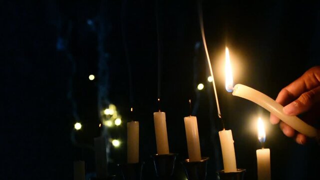 Hanukkah celebration candles glowing on a black background with warm festive light. Traditional Jewish holiday decoration featuring menorah candle flames, spiritual atmosphere, cultural symbolism, and