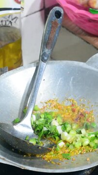 Homemade seblak cooking process with various toppings in a home kitchen. Popular Indonesian spicy street food prepared with authentic ingredients, flavorful seasonings, noodles, crackers, and assorted