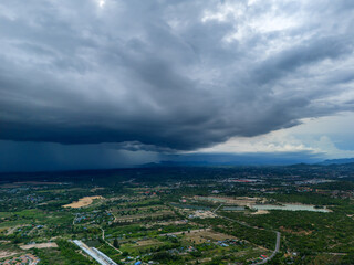 Aerial Drone Shot of Heavy Rain Clouds Spreading Across Tropical Valley During Monsoon Season