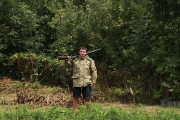 Hunter in camouflage jacket with antique double-barreled shotgun