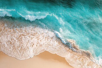 High-angle view of turquoise waves lapping sandy shore