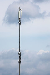Fototapeta premium A Tall Telecommunication Mast With 5G And 4G Cellular Antennas Against A Cloudy Sky. Mobile Communication Technology. Vertical Shot.