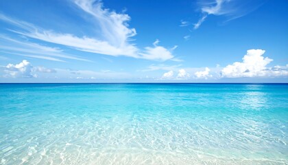 Serene turquoise ocean meets a vibrant blue sky, dotted with wispy clouds