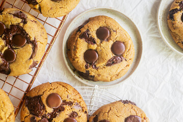 Homemade chocolate chip cookies on a cooling rack and ceramic plates