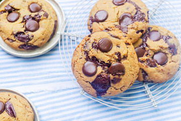 Homemade chocolate chip cookies on a cooling rack and ceramic plates