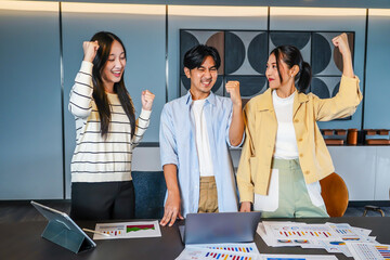 Vibrant business team consisting of diverse individuals joyfully raises their fists in celebration of a significant achievement, Celebrating success in a business team with joyful expressions