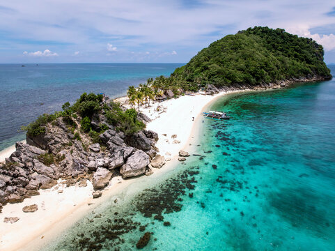 Aerial view of vibrant turquoise waters meet pristine white sands and lush greenery on this tropical island paradise, Gigantes Islands, Carles, Philippines.