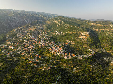 Aerial view of the terracotta rooftops nestled amid the verdant hillsides, a tapestry of civilization woven into nature's embrace, Douma, North Governorate, Lebanon.
