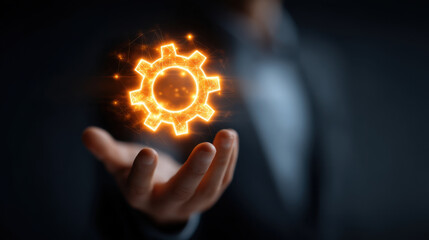Hand holding glowing gear symbolizing innovation and technology, representing progress and creativity in business environment