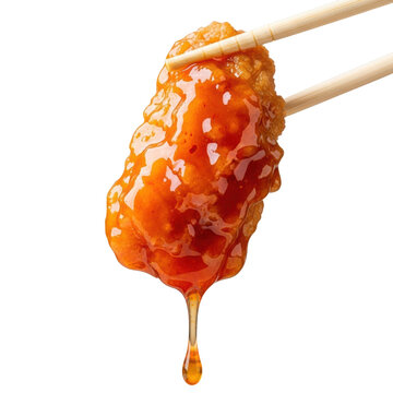 Golden-brown orange chicken with crispy texture, thick, glossy orange-red sauce dripping, held by wooden chopsticks on transparent background, appetizing food photography concept