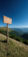 Blank Signboard on Mountain Slope Against Blue Sky
