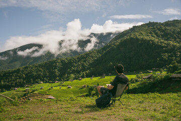 ecology travel with man solo travel and camping outdoor relax in rice field at chiangmai thailand in raining season