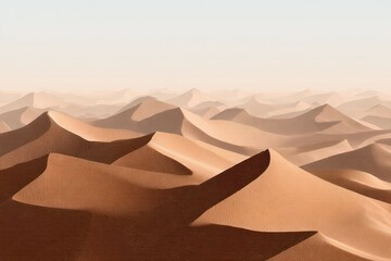 Endless expanse of gently sloping, light-brown sand dunes disappearing into a hazy horizon under a bright, cloudless sky