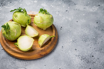 Raw kohlrabi sliced on pieces on wooden tray. grey backround. top view