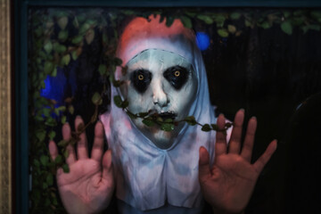 Scary devilish nun look through window at night.Haloween 2025