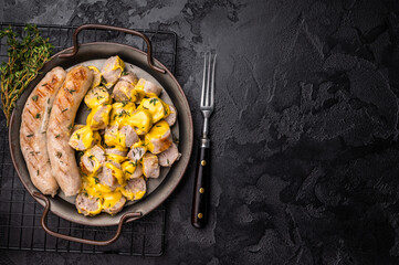 Currywurst sliced Sausages with curry sauce, wurst in steel plate. black background. top view