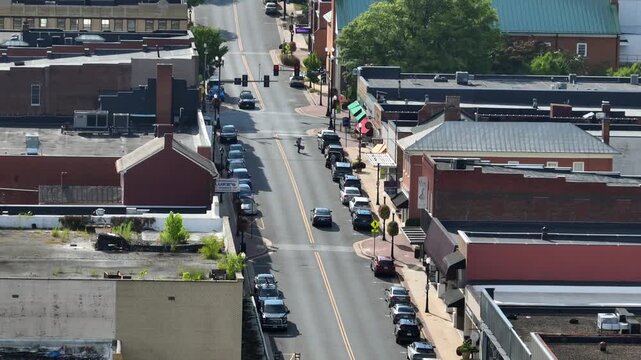 Main Street of America town ln with red brick building and pedestrian crossing road. Sunny summer day in Waynesboro, Virginia. drone wide shot.