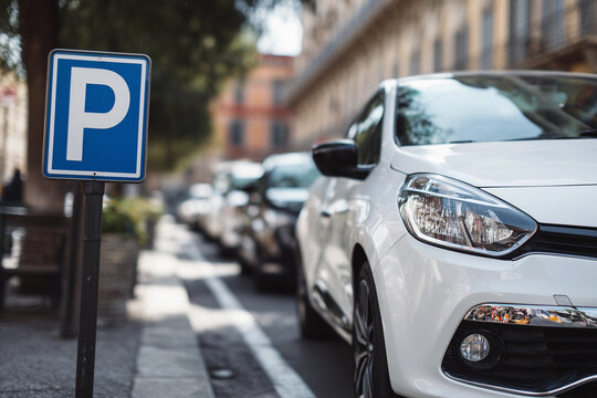 P plate driver practicing parallel parking on a city street during a driving lesson in an urban neighborhood