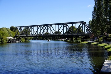 Scenic landscape panorama of a boat crossing the historic railway bridge over river Havel in Caputh, Brandenburg, Germany