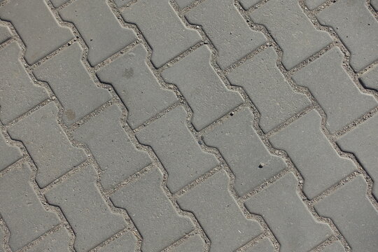 Dusty surface of gray concrete dumble interlocking pavement
