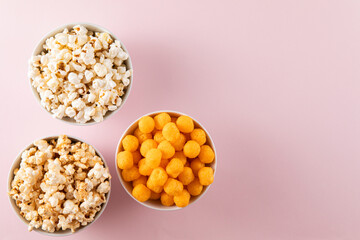 Popcorn and snacks on pink background