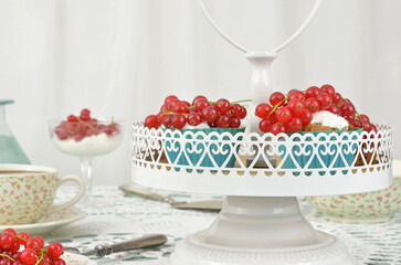 Cupcakes with cream and red fruits on a white tray with hearts, delicate cups; blue and red elements for a wedding, anniversary, birthday or engagement.