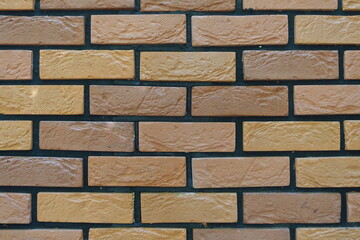 Texture of brick veneer wall with stretcher bond pattern in shades of brown