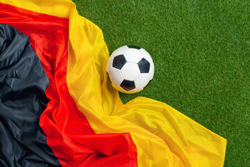 German soccer ball and flag with green grass copy space. © Igor Link