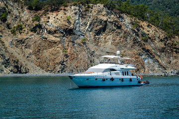 Kemer. T&uuml;rkiye. July 15th, 2025. Yacht in the bay against the background of cliffs in the Mediterranean Sea.