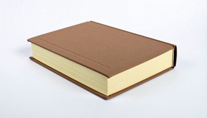A closed hardback book with a light beige interior lies angled on a plain white surface.