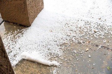 A large pile of snow is sitting on the ground next to a brick structure