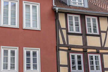 Traditional half timbered house and red plastered building with multiple windows in Germany