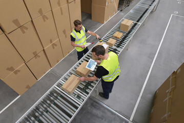 Worker in a warehouse in the logistics sector processing packages on the assembly line  - transport and processing of orders in trade