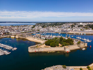 Aerial photograph of the walled town of Concarneau in Brittany, France. The image highlights the fortified walls, historic buildings, and surrounding harbor