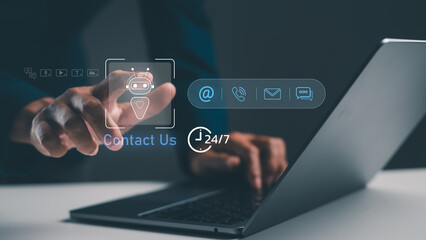 A hand interacts with a laptop, displaying contact options and a chatbot icon, symbolizing online...