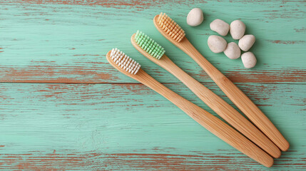 Three bamboo toothbrushes on mint green wooden background, flat lay, mockup template.