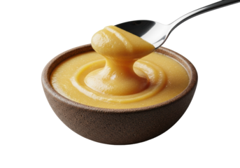 Extreme close-up macro of a silver spoon scooping glistening golden frangipane almond paste from a rustic ceramic bowl on a transparent background, concept of luxurious dessert indulgence